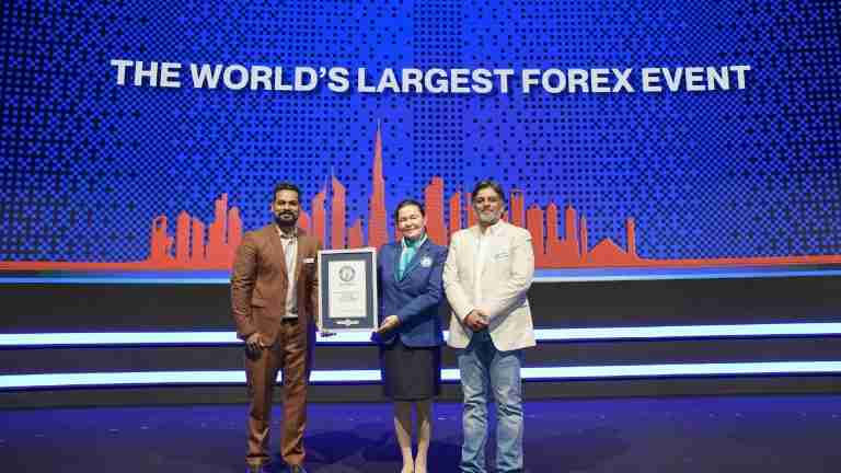 Forex Expo Dubai representatives and a Guinness World Records official present the attendance record certificate on stage